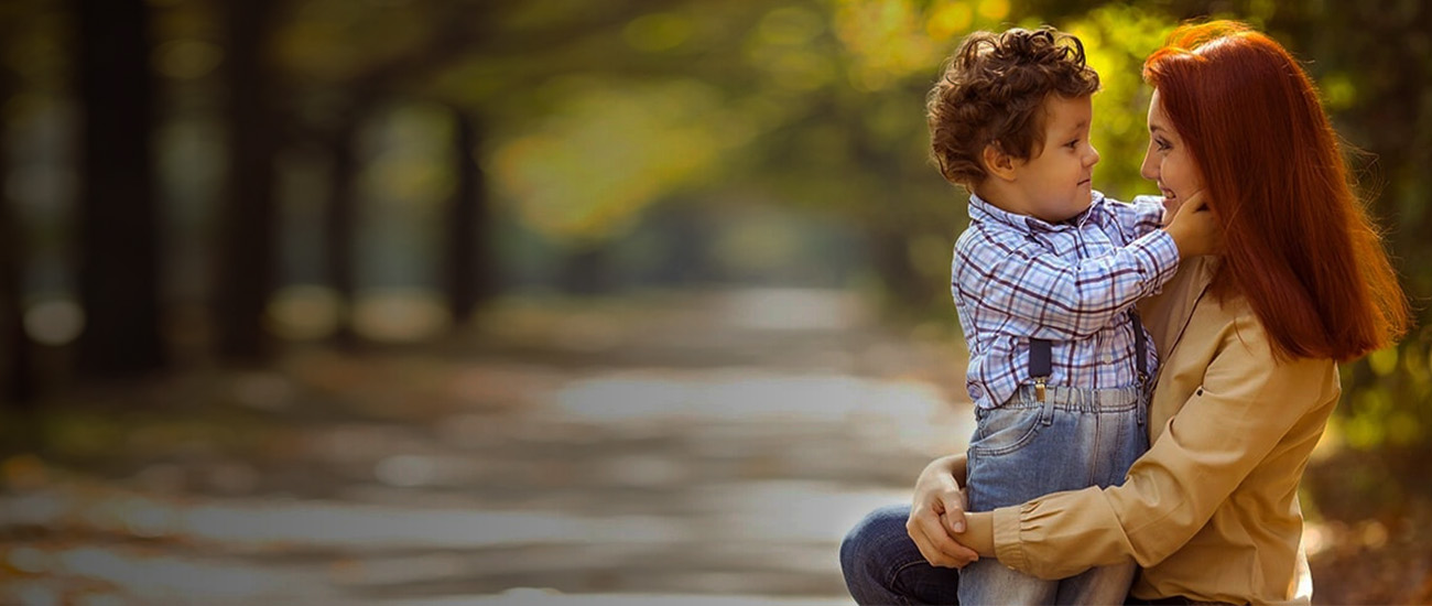 A woman and a child sit on the ground, enjoying each other's company in a serene setting.